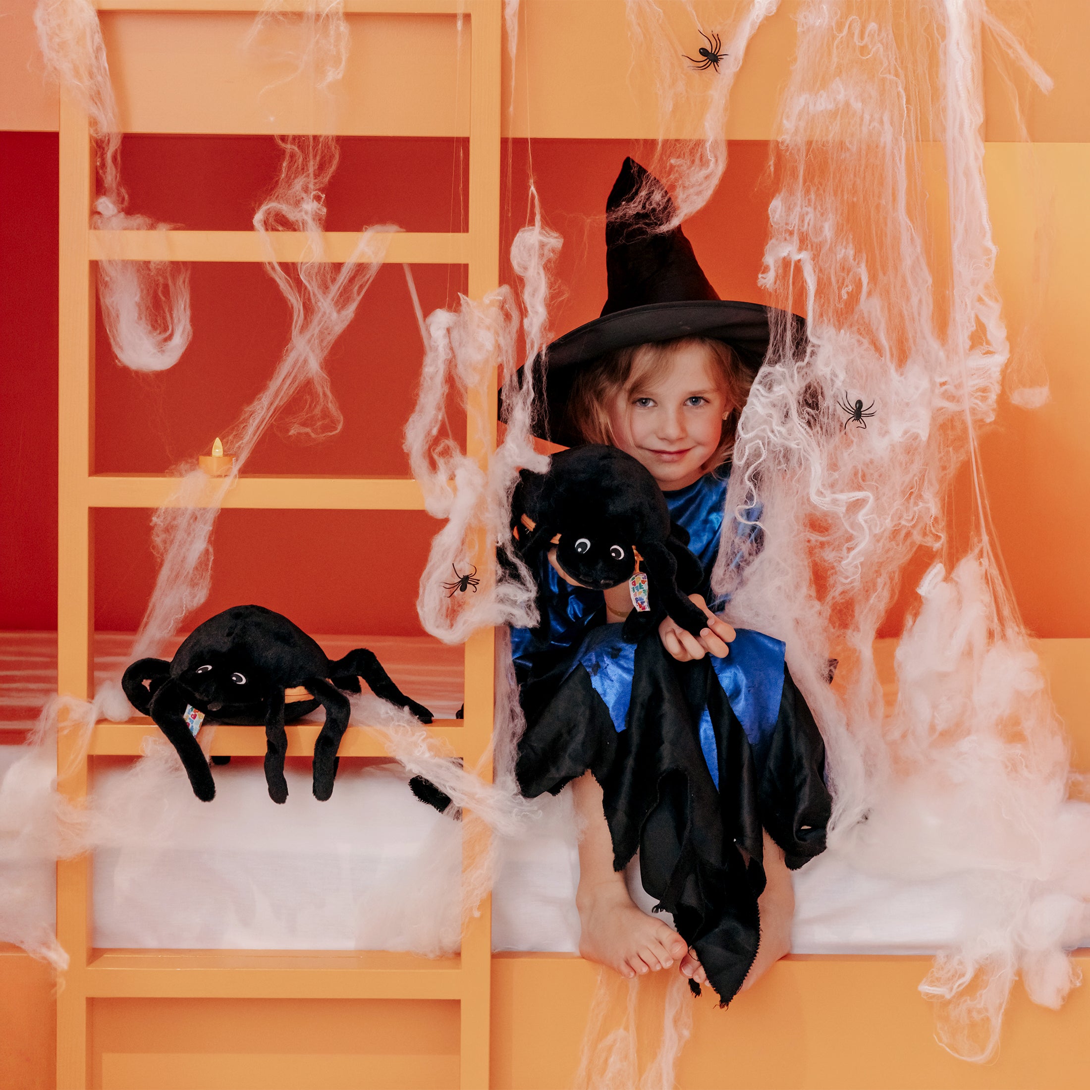 Peluche Pumpet la citrouille/araignée - visuel d'ambiance d'une fille déguisée en sorcière et tenant une araignée entre ses mains - Flipetz