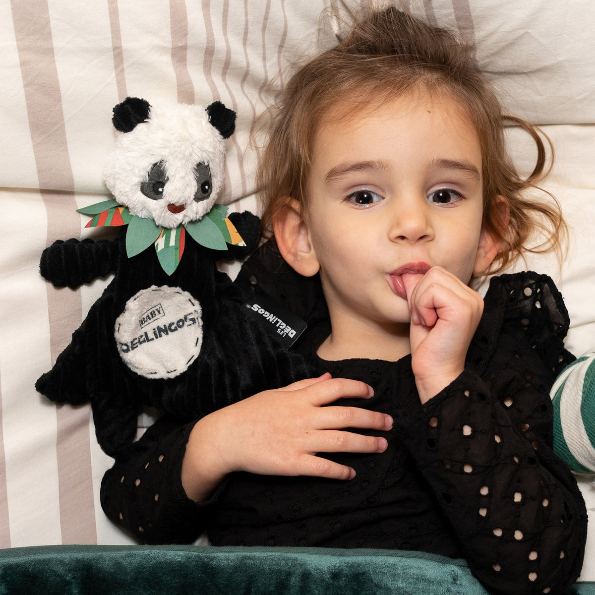 Doudou baby Rototos le panda - visuel d'ambiance d'une petit fille dans son lit avec son doudou baby panda - Les Déglingos