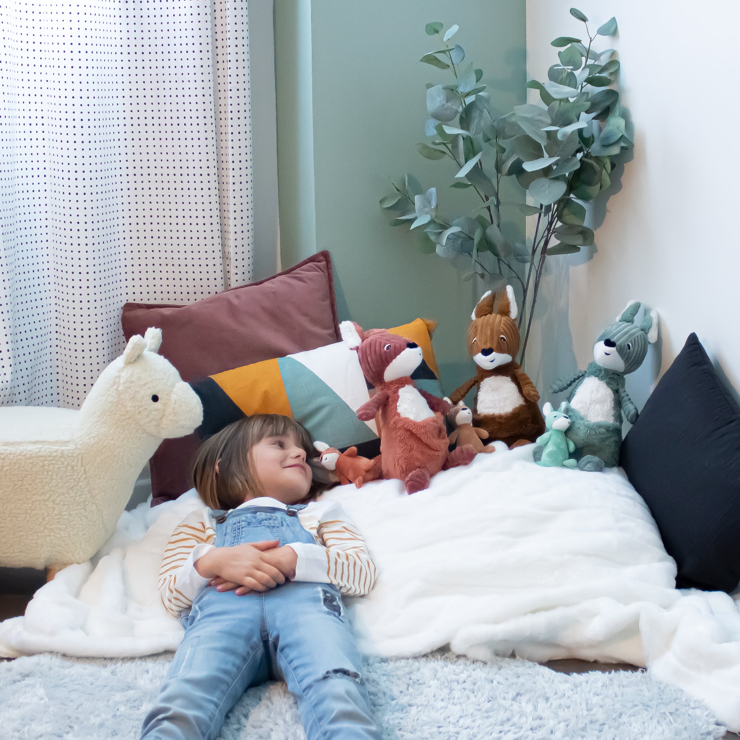 Peluche kangourou Allezou maman et son bébé terracotta - visuel d'ambiance d'une petite fille jouant avec ses peluches kangourou - Les Ptipotos